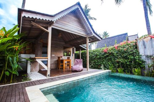 un complejo con piscina, mesa y casa en Camilla Resort, en Gili Air
