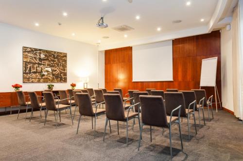 a conference room with chairs and a projection screen at Exe Toscana in Lucca