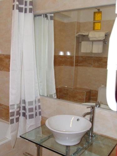 a bathroom with a sink and a glass table at Elimeia 3 Hotel in Aiani