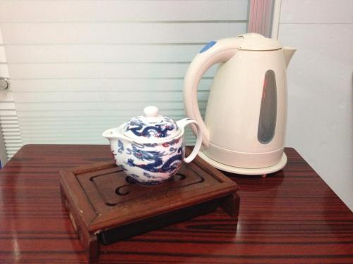a blue and white pitcher and a tea pot on a table at Asia Travel House in Hong Kong