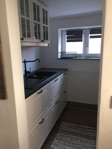 a kitchen with a sink and white cabinets at Ilmhaus 2 in Gaden bei Pförring