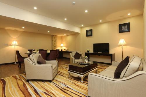 a living room with white furniture and a television at Al Muhaidb Residence Al Ahsa in Al Ahsa