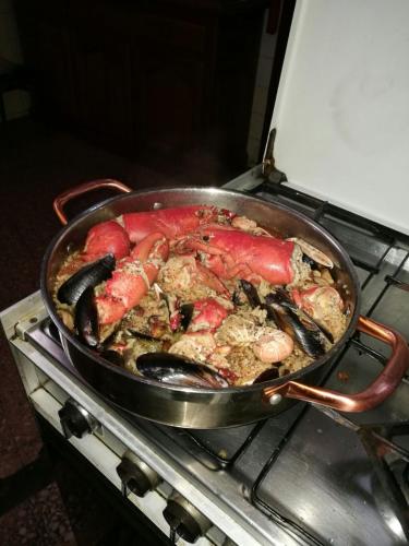 a pan of food on top of an oven at Residencia Los Conejos - Bike & Motorbike in Las Palmas de Gran Canaria