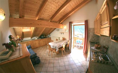 a kitchen with a table in the middle of a room at Appartamenti Majon Ladina in Vigo di Fassa