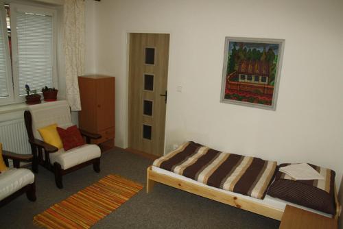 a living room with a bed and a chair at Zelený dům in Svoboda nad Úpou
