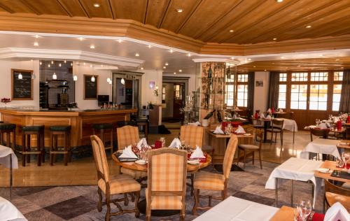 a restaurant with tables and chairs and a bar at De France by Thermalhotels in Leukerbad