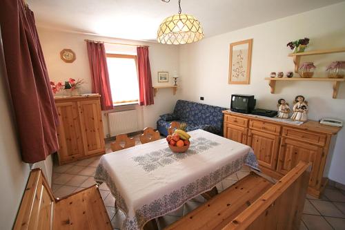 a kitchen with a table with a bowl of fruit on it at Appartamenti Majon Ladina in Vigo di Fassa