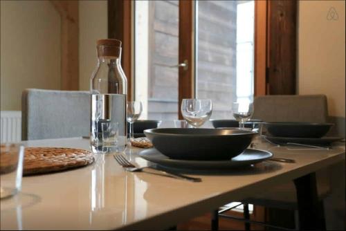 a table with a glass bottle and plates and glasses at Chamonix Apartment in Chamonix