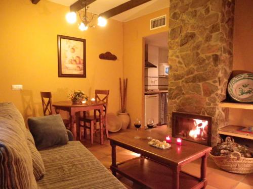 ein Wohnzimmer mit einem Kamin und einem Tisch mit Kerzen in der Unterkunft Hotel Apartamento Rural Finca La Media Legua in Aracena