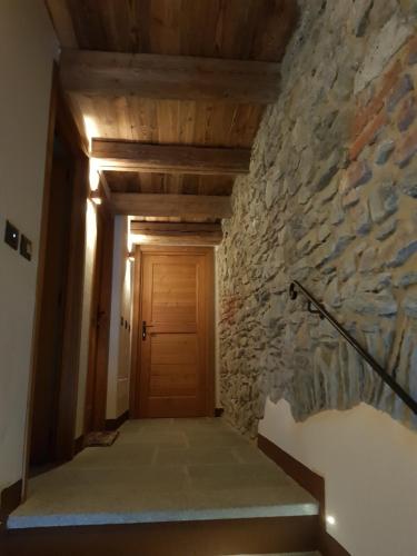 a hallway with a stone wall and a wooden door at Il rifugio delle marmotte in Pré-Saint-Didier