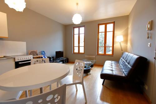 une cuisine et un salon avec une table et des chaises dans l'établissement Appart'Hôtel de la Tour, à Troyes