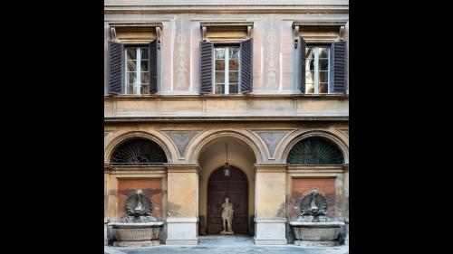 a building with two statues in front of it at Nobildonne Relais in Rome