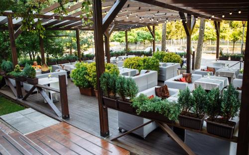 a patio with potted plants under a pergola at Jolly Alon Hotel in Chişinău