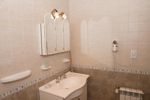 baño con lavabo, espejo y teléfono en Cabañas de Nené Aparts en El Calafate
