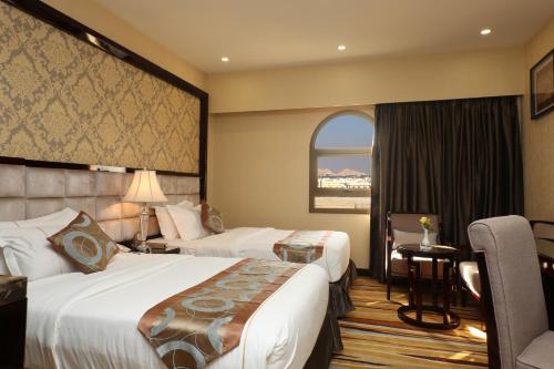 a hotel room with two beds and a window at Al Muhaidb Residence Al Ahsa in Al Ahsa