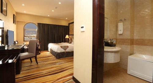 a hotel room with a bed and a bathroom at Al Muhaidb Residence Al Ahsa in Al Ahsa