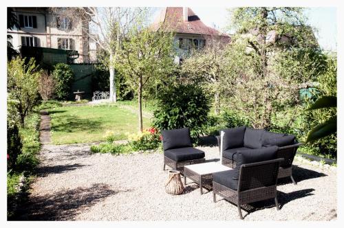 two chairs and a table in a yard at Bed & Kitchen am Tavelweg - Adults Only in Bern