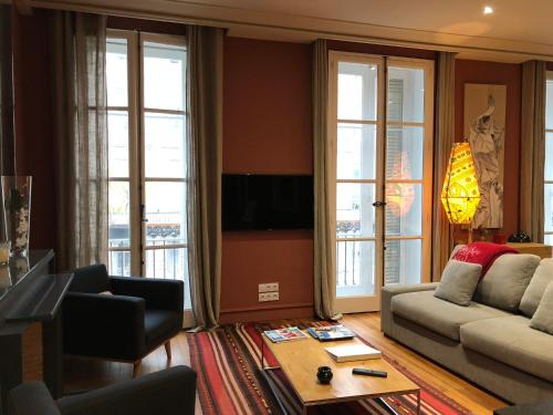 a living room with a couch and a table at Maison d'hôtes Bordeaux Centre Le Patio de l'Intendance in Bordeaux