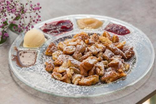 a plate of food on a glass plate with desserts at Gasthof Edelbrunn in Ramsau am Dachstein