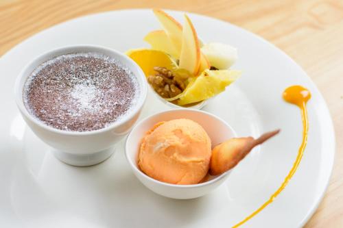 a white plate with two cups of food and fruit at Pazo de Mendoza in Baiona