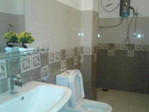 a bathroom with a toilet and a sink and a shower at Apna Homestay Apartments in Unawatuna