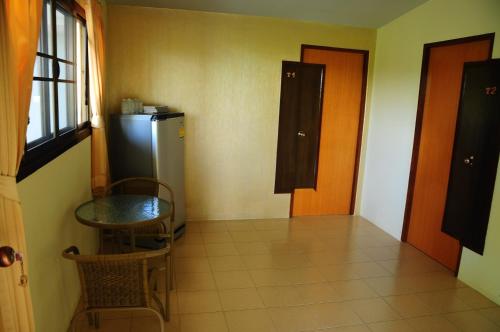 a small room with a table and a refrigerator at Phumimalee Nature View Resort in Nakhon Ratchasima