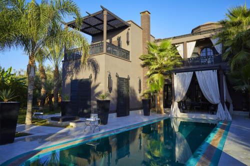 a house with a swimming pool in front of a house at Villa Mano in Marrakech
