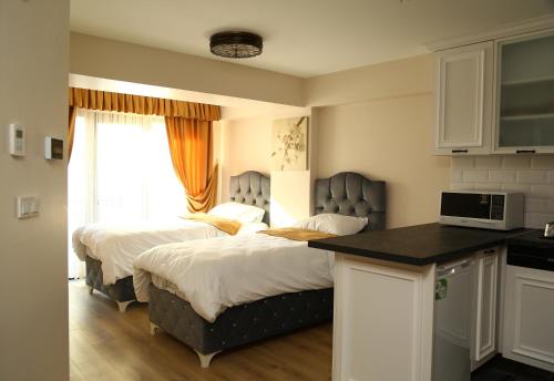 ein Schlafzimmer mit 2 Betten und eine Küche mit einer Theke in der Unterkunft Luxx Suite Nişantaşı in Istanbul
