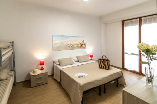 シルヴィ・マリーナにあるZaffiro Luxury Silvi Vacanzaのベッドルーム1室(ベッド1台、ソファ、窓付)