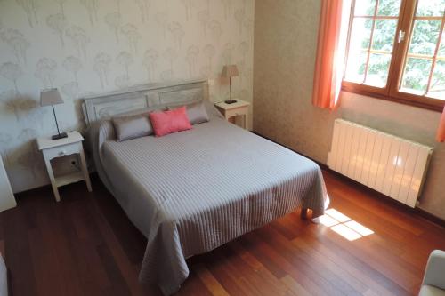 um quarto com uma cama com duas mesas e duas janelas em Le jardin des paons em Issac