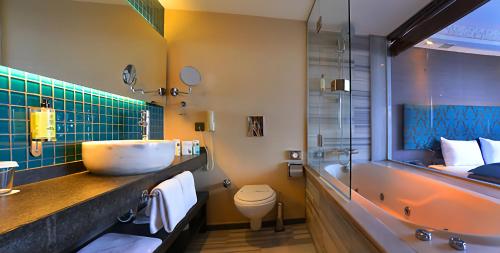 a bathroom with a sink and a tub and a toilet at Pera Tulip Hotel & Spa - Istanbul Taksim Pera City Center in Istanbul