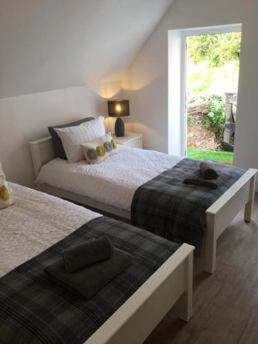 a bedroom with two beds and a window with a view at 5, Sandleigh Apartment in Woolacombe