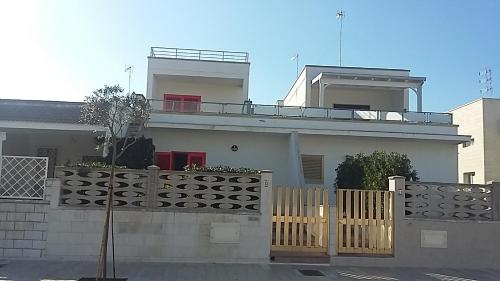a white house with a fence in front of it at Monolocale sul Lungomare San Foca in San Foca
