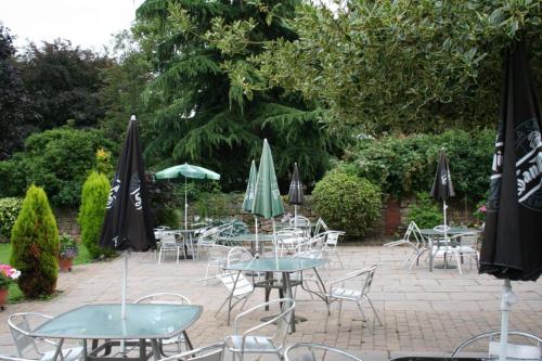 a patio with tables and chairs with umbrellas at The Angel Inn (Blyth) in Blyth