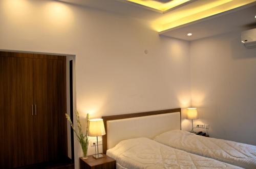 een slaapkamer met een bed en 2 verlichting aan het plafond bij Orania B & B by Atsar in New Delhi