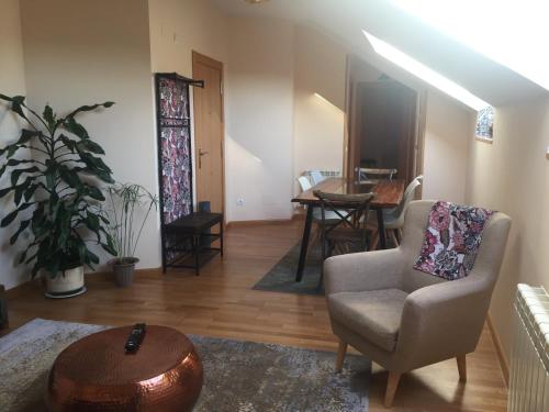uma sala de estar com uma cadeira e uma mesa em Apartamento Conde Luna em León