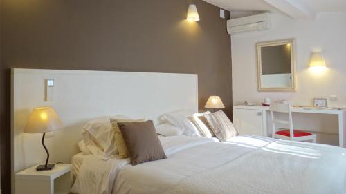 Schlafzimmer mit einem weißen Bett und einem Schreibtisch in der Unterkunft Le Mas des Ecureuils in Aix-en-Provence