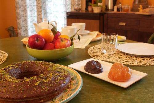 a table with a chocolate cake and a bowl of fruit at B&B VELARDI in Viagrande