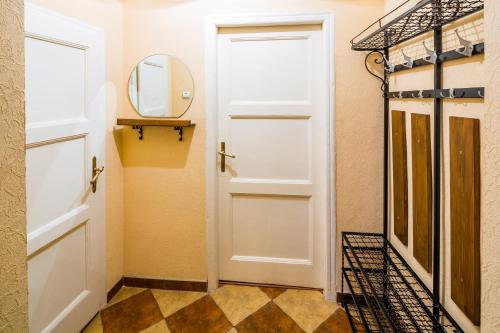 ein Badezimmer mit einer weißen Tür und einem Spiegel in der Unterkunft Apartment Krakivska 15 in Lwiw