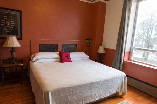 a bedroom with a bed with a red wall at Centralia Square Grand Ballroom and Vintage Hotel in Centralia