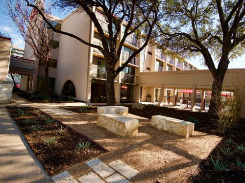 a building with two stone benches in front of it at Ramada by Wyndham Austin South in Austin