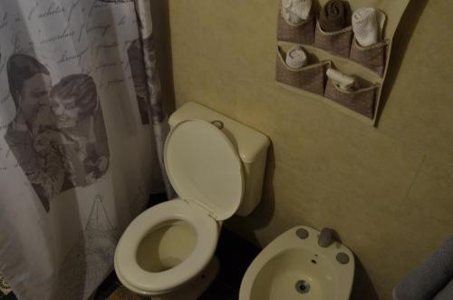 a bathroom with a toilet and a poster of a man at Maravillosa in La Pedrera