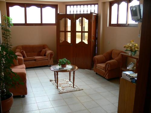 un soggiorno con divani e un tavolo con una pianta di Hostal Vista Hermosa a Chachapoyas