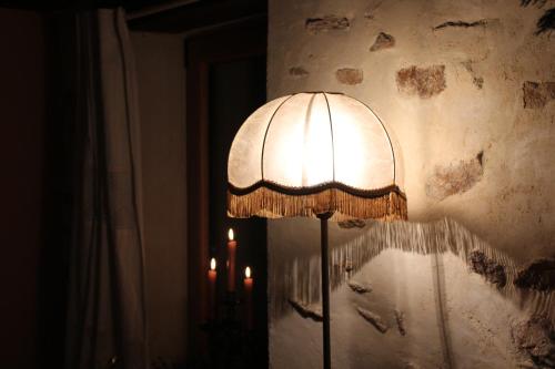 a lamp in the corner of a room next to a wall at La Tour du Bois Dormant in Plozévet