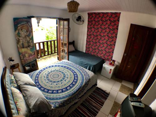 a small room with a bed and a balcony at Pousada Tia Cleide in Caraguatatuba