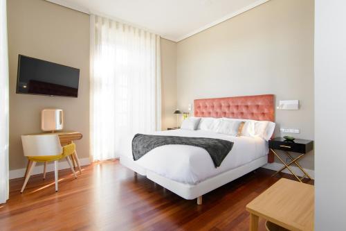 a bedroom with a bed and a desk and a tv at Pazo de Mendoza in Baiona
