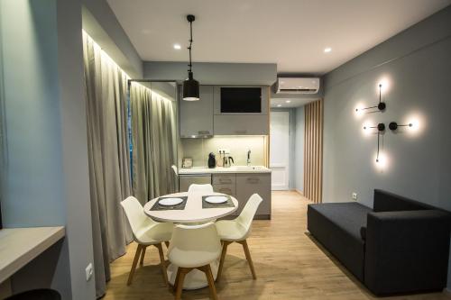 een woonkamer met een tafel en stoelen en een keuken bij Preveza Suite Stay Leoforos Irinis 84b in Preveza