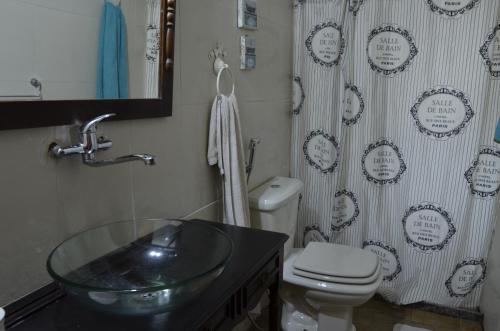 Un baño con lavabo, inodoro y cortina de ducha. en Los Superabuelos, en La Pedrera