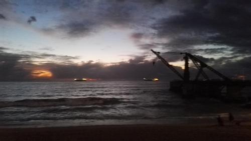 a crane in the ocean with a sunset in the background at Departamento Frente al Mar in Viña del Mar