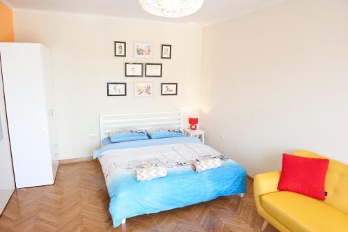 una camera da letto con un letto e un divano giallo di Atelje apartment a Belgrado